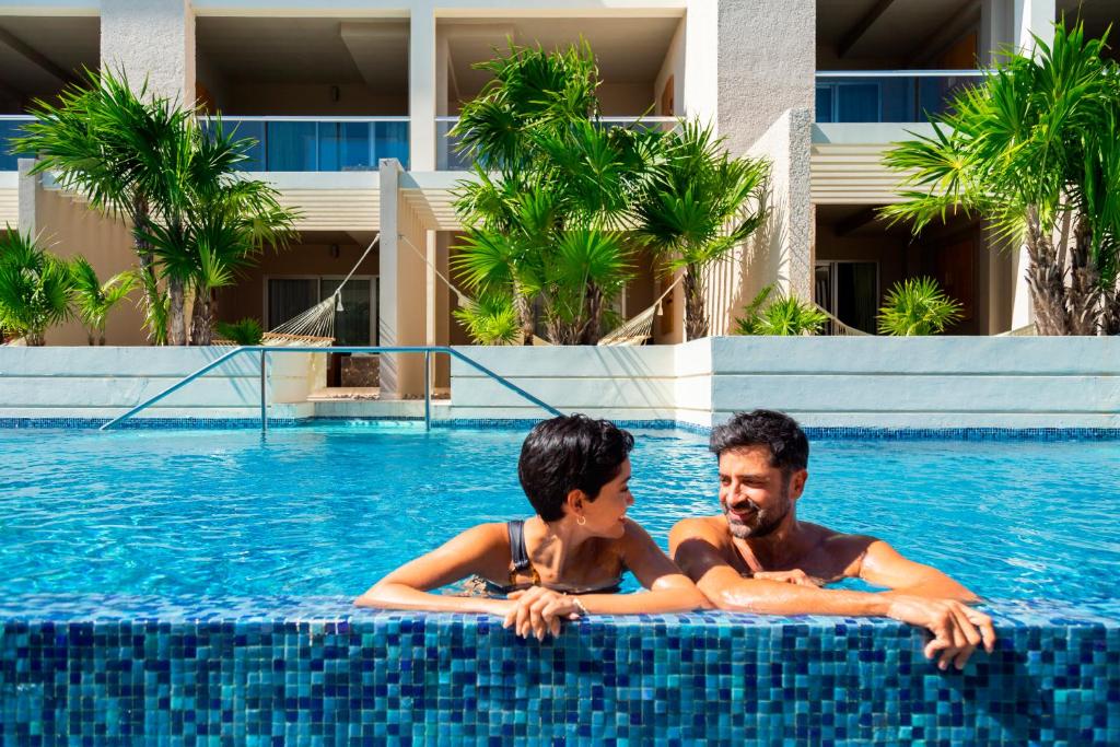two men in the swimming pool at a resort at Paradisus La Perla - Adults Only All Inclusive in Playa del Carmen