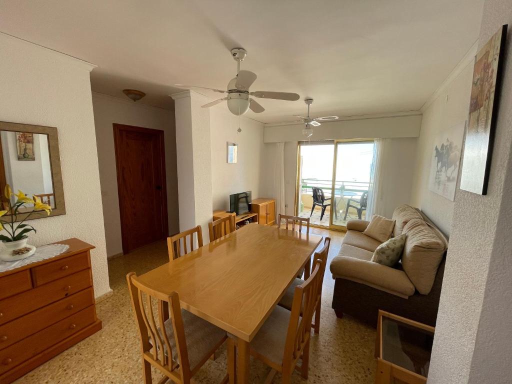 - une salle à manger et un salon avec une table et un canapé dans l'établissement Apartamento en segunda linea en playa de Gandia, à Playa de Gandia