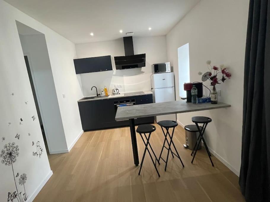 eine Küche mit einer Theke und Hockern in einem Zimmer in der Unterkunft Appartement T2 à centre ville in Brive-la-Gaillarde