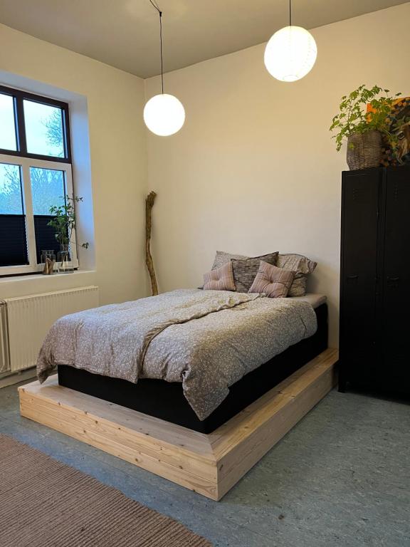 a bedroom with a bed on a wooden platform at Room 8 - Hawkraft kulturhotel in Vestervig