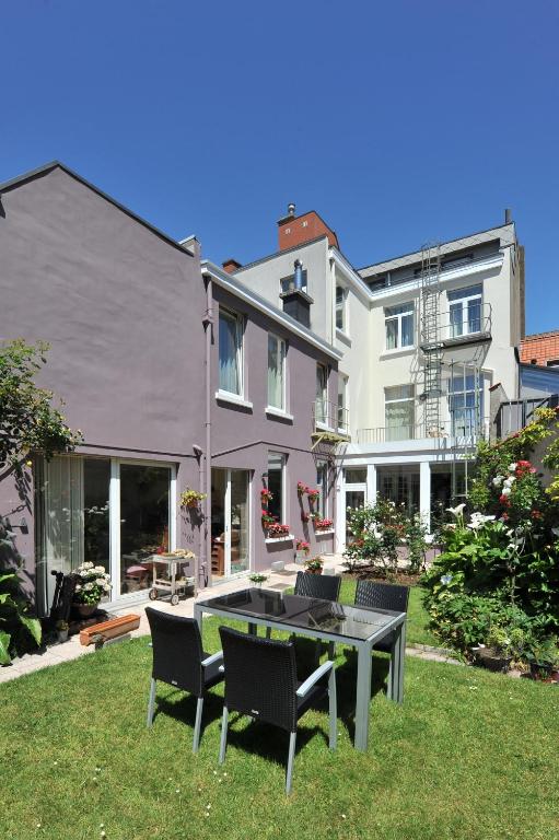 a house with a table and chairs in the yard at Hotel Manitoba in Blankenberge