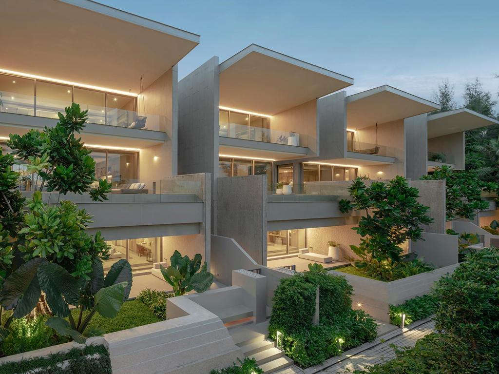 an exterior view of a large apartment building at night at Veyla Natai Residences - Luxury Pool Villa in Khok Kloi