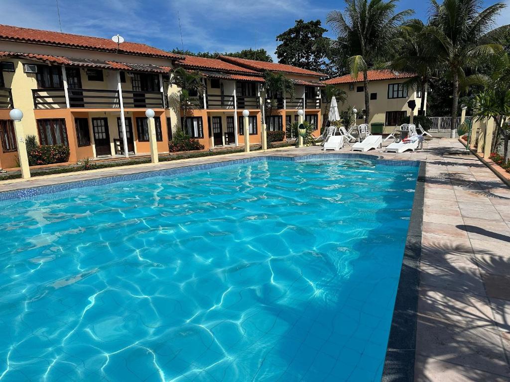 uma piscina em frente a um hotel em A 200m da praia de Taperapuã Axé Moi 2 suítes, churrasqueira privativa, piscina, sauna portaria 24hrs e internet privativa 300MBPS em Porto Seguro