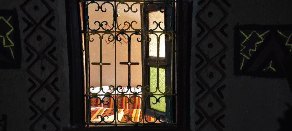 Una puerta con una ventana de cristal con botellas. en Prends Ton Temps en Zagora