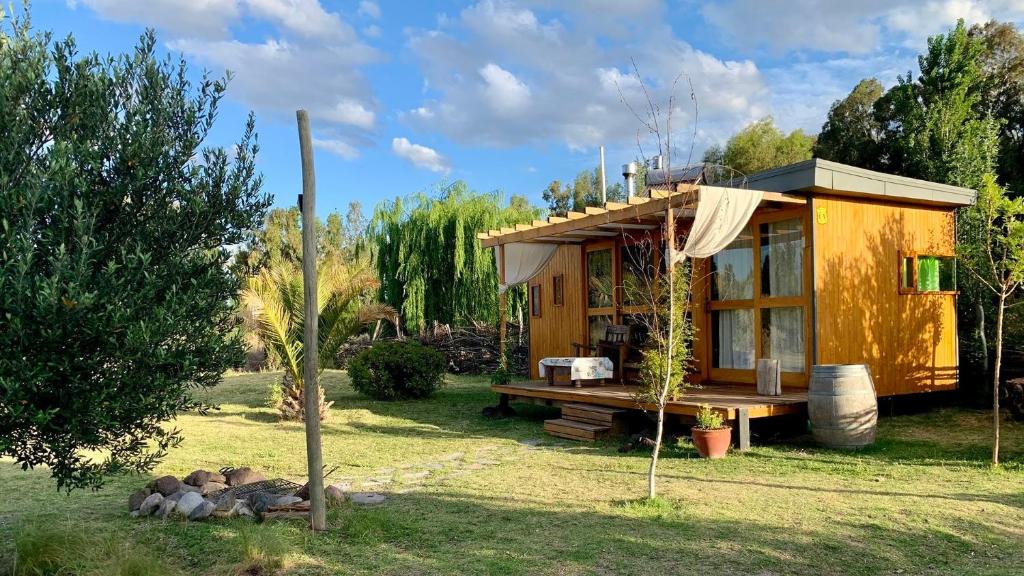 una pequeña casa amarilla en un patio con árboles en Para los amantes de la naturaleza en San Rafael