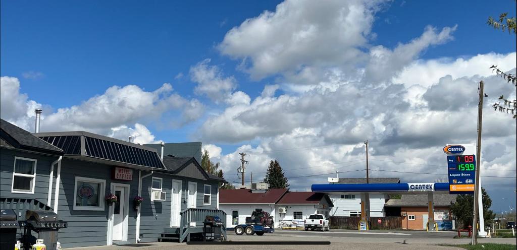 ピンチャー・クリークにあるWest Castle Motelの曇天の小さな町のガソリンスタンド