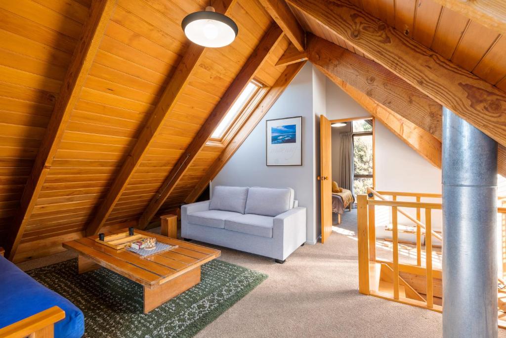 a living room with a couch and a table at Totara Lodge - Unwind, Relax & Enjoy - Mt Lyford in Mt Lyford