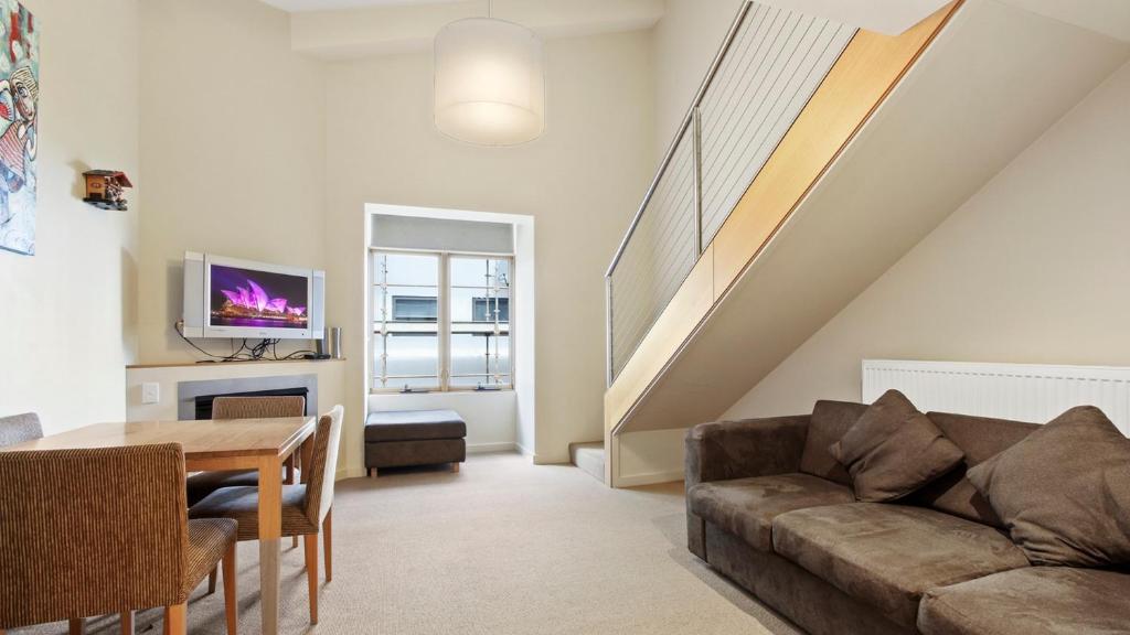 a living room with a couch and a table at Chalet Hotham 17 in Mount Hotham