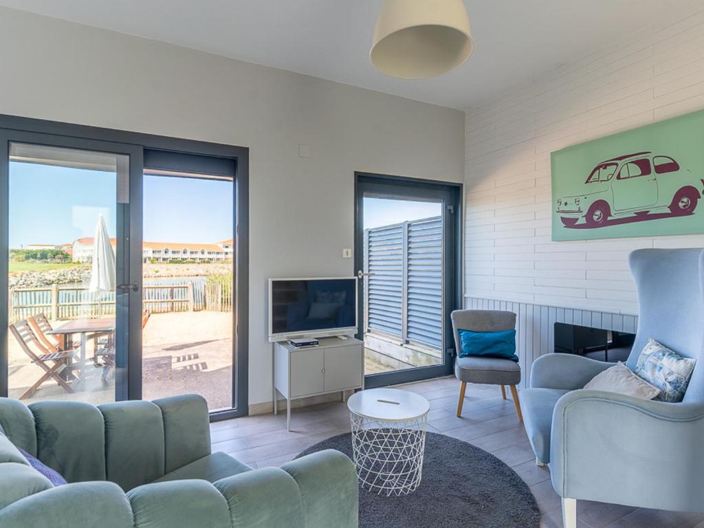 un salon avec un canapé, des chaises et une télévision dans l'établissement Superbe T3 rénové à 200m de l'océan avec terrasse et parking privatif - FR-1-50-74, à Mimizan