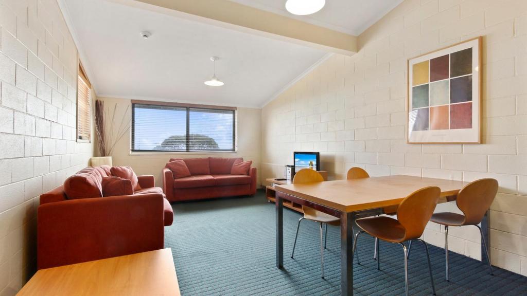 a living room with a table and chairs and a couch at Alpine Heights 04 in Mount Hotham
