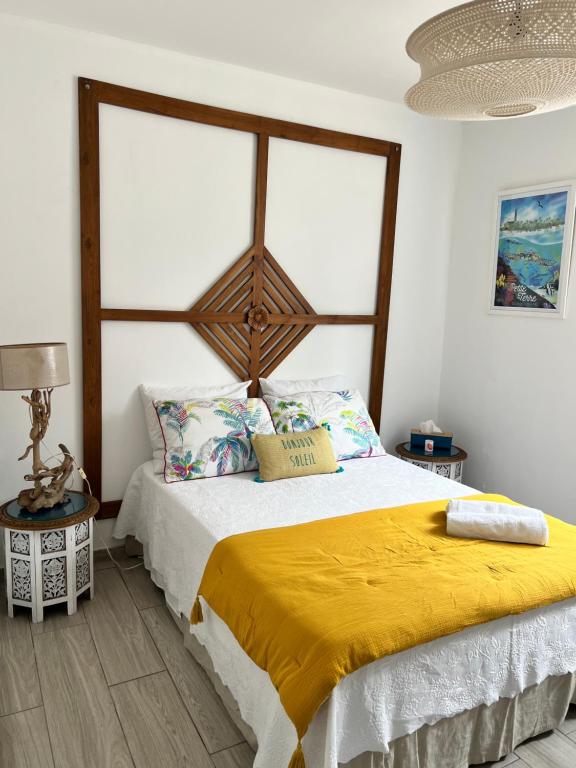 ein Schlafzimmer mit einem großen Bett und einer gelben Decke in der Unterkunft Ti bwa Lodge in Capesterre-Belle-Eau