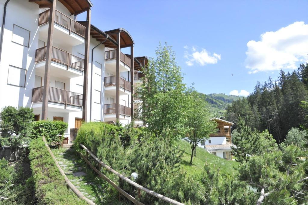 an apartment building on a hill with trees at Residence Nagler - BelaVal Apartments in Badia