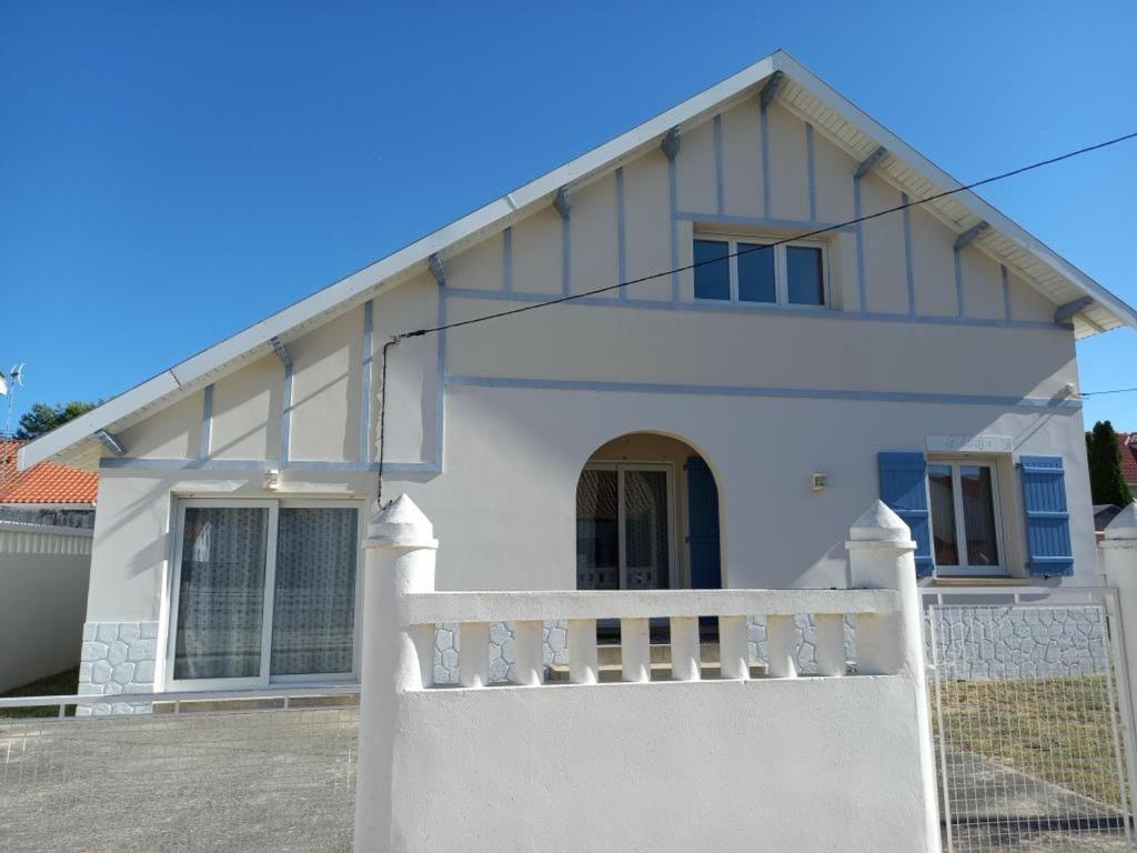 une maison blanche avec une clôture blanche devant elle dans l'établissement Maison familiale à 2 pas de la plage - 7 pers, jardin, terrasse, WIFI, bien équipée - FR-1-540-149, à Notre-Dame-de-Monts