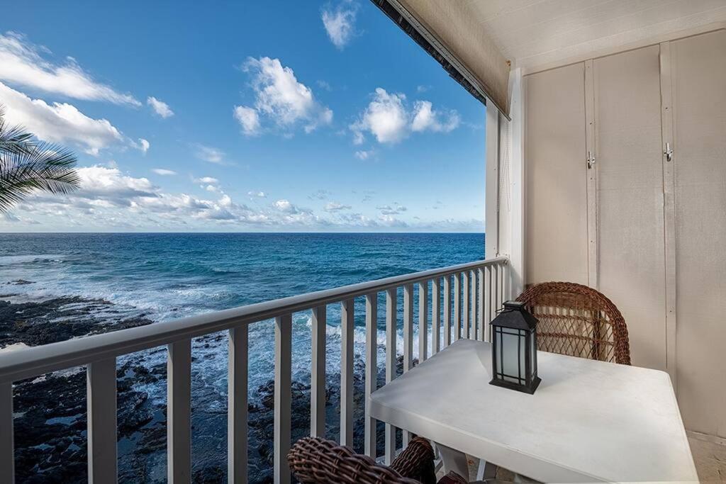 凱魯瓦的住宿－Wonderful Modern Oceanfront Condo - Hale Kona Kai 408 by Casago Kona，阳台配有桌子,享有海景。