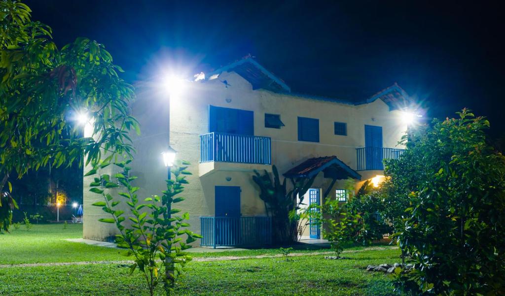 a white house with blue windows at night at Stallage Hotel in São Pedro