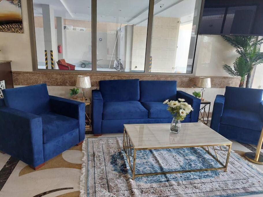 a living room with blue couches and a coffee table at غرفة وصالة فاخرة حي السلامة in Jeddah