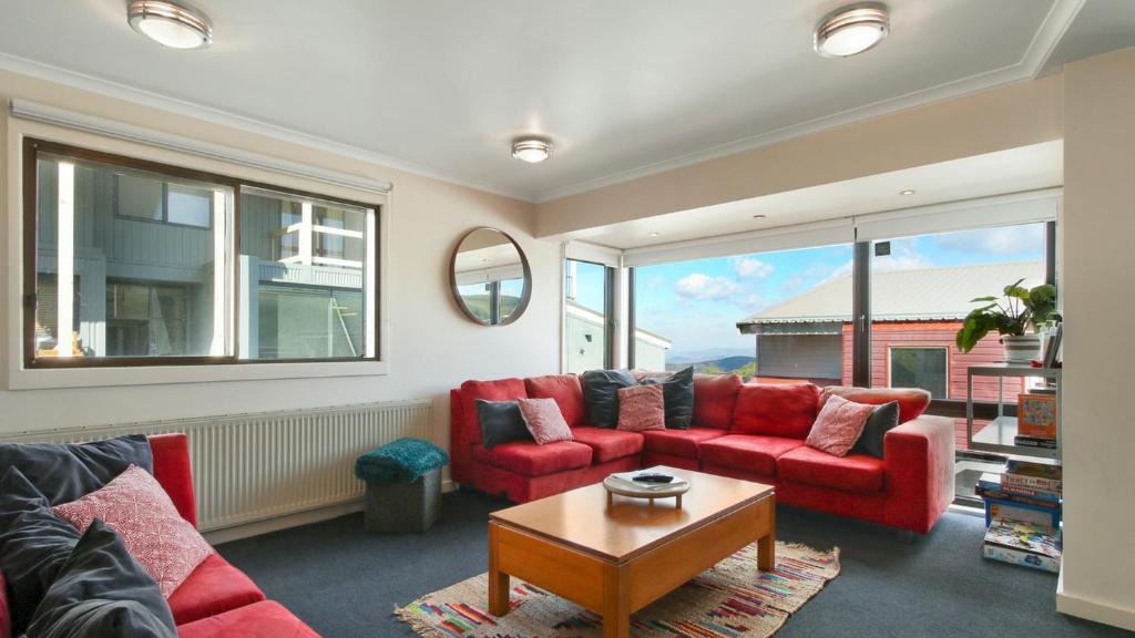 sala de estar con muebles de color rojo y ventana grande en Lawlers 30, en Monte Hotham