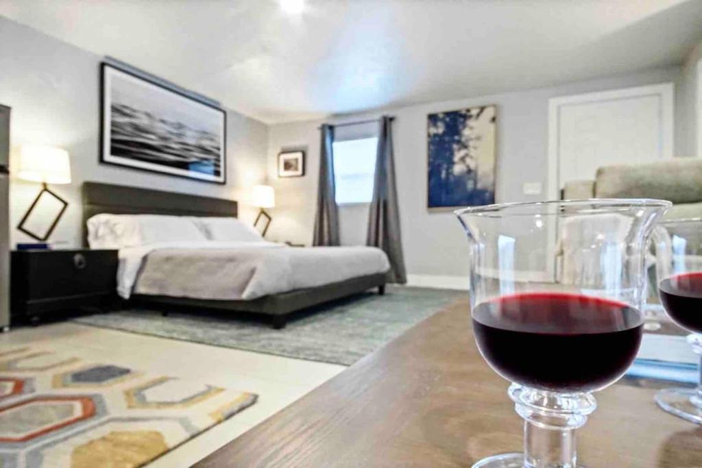 een glas wijn op een tafel in een slaapkamer bij Summer Refresh-modern Comfort Near Downtown 40-4 in Oklahoma City