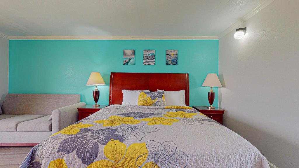 a bedroom with a bed and a blue wall at CRYSTAL PALACE RESORT in Bolivar Peninsula