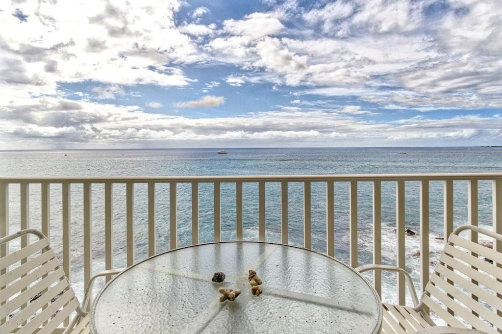 カイルア・コナにあるTrue and Absolute Oceanfront Condo Breathtaking Views From The Lanai - Hale Kona Kai 402 by Casago Konaの海を見渡すバルコニー(テーブル、椅子付)