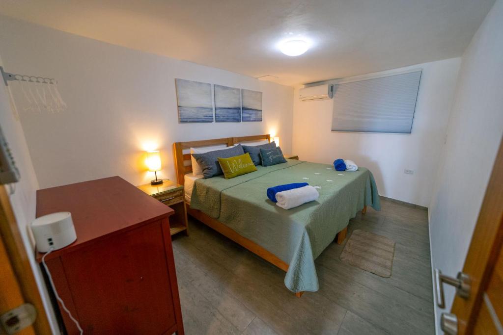 1 dormitorio con 1 cama con colcha verde en WOW location Kite Beach Oceanfront 2 Bedroom Patio and Pool, en Cabarete