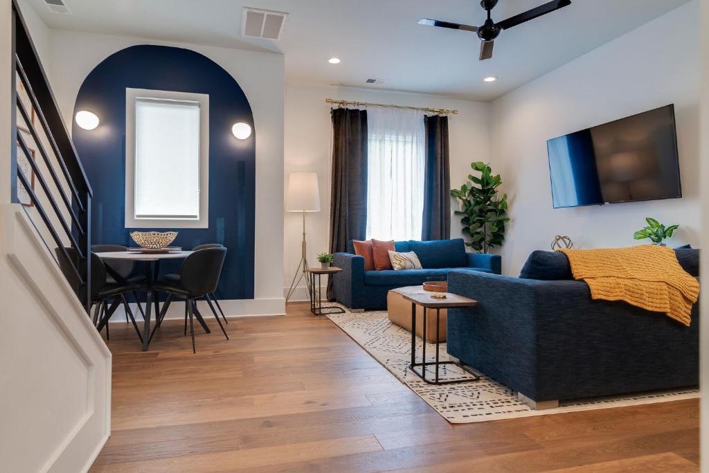 a living room with a blue couch and a table at Taylor Haus II - Stylish Stay with Rooftop, Close to Fun in Nashville