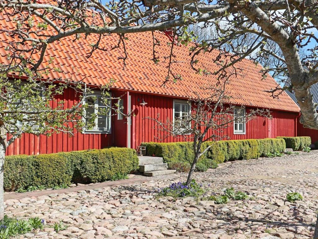 una casa roja con un árbol delante en 6 person holiday home in BÅSTAD-By Traum, en Båstad