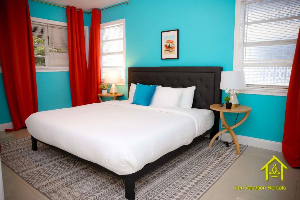 a bedroom with a large white bed and blue walls at BH Club By Zen Vacation Rentals in Miami Beach