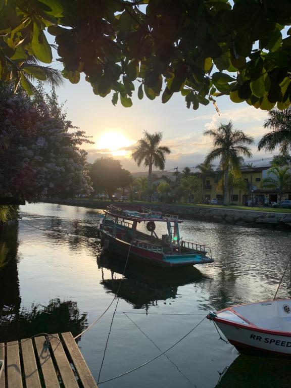 un bateau est amarré sur une rivière au coucher du soleil dans l'établissement Hostel 420, à Parati