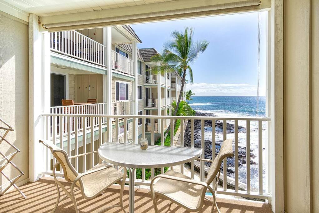 d'un balcon avec une table et des chaises donnant sur l'océan. dans l'établissement Oceanfront Blissful Sanctuary! - Hale Kona Kai 308 by Casago Kona, à Kailua-Kona