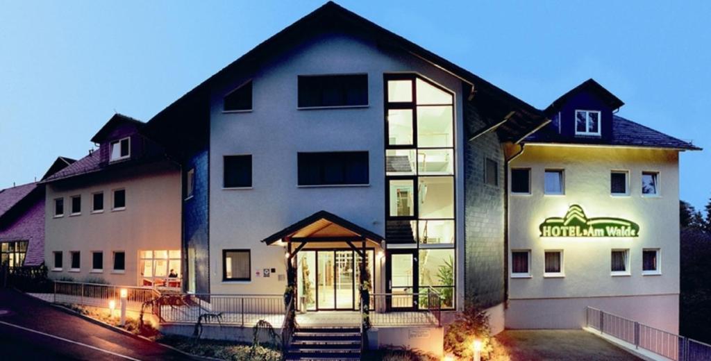 een groot wit gebouw met een bord erop bij Hotel Am Wald -GARNI- in Elgersburg
