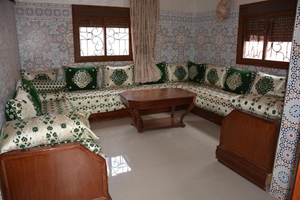 sala de estar con sofás, mesa y ventanas en Ozoud high standing appartment, en Ouzoud