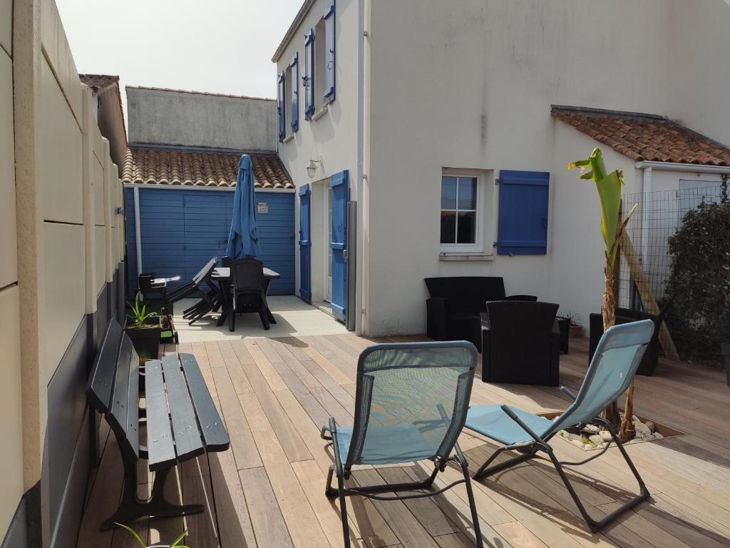 un patio avec des chaises et un banc sur une terrasse dans l'établissement Maison ensoleillée proche plage de la Grière, 4 pers., terrasse, WiFi, parking privé - FR-1-194-239, à La Tranche-sur-Mer