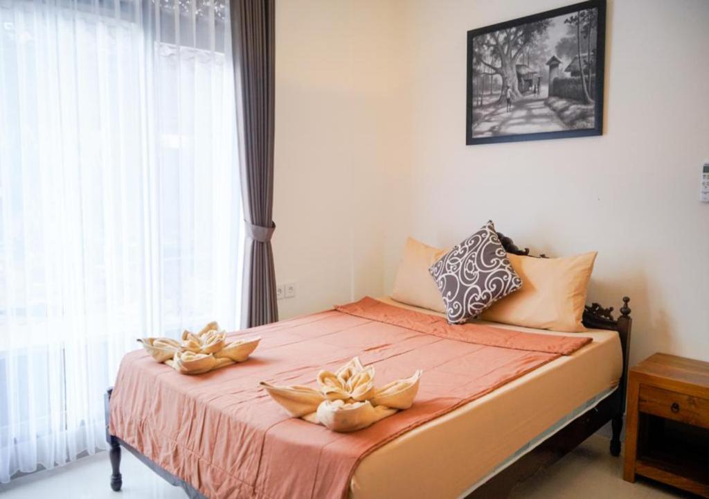 - une chambre avec un lit fleuri dans l'établissement Adipana Bungalow-Balinese Room, à Ubud