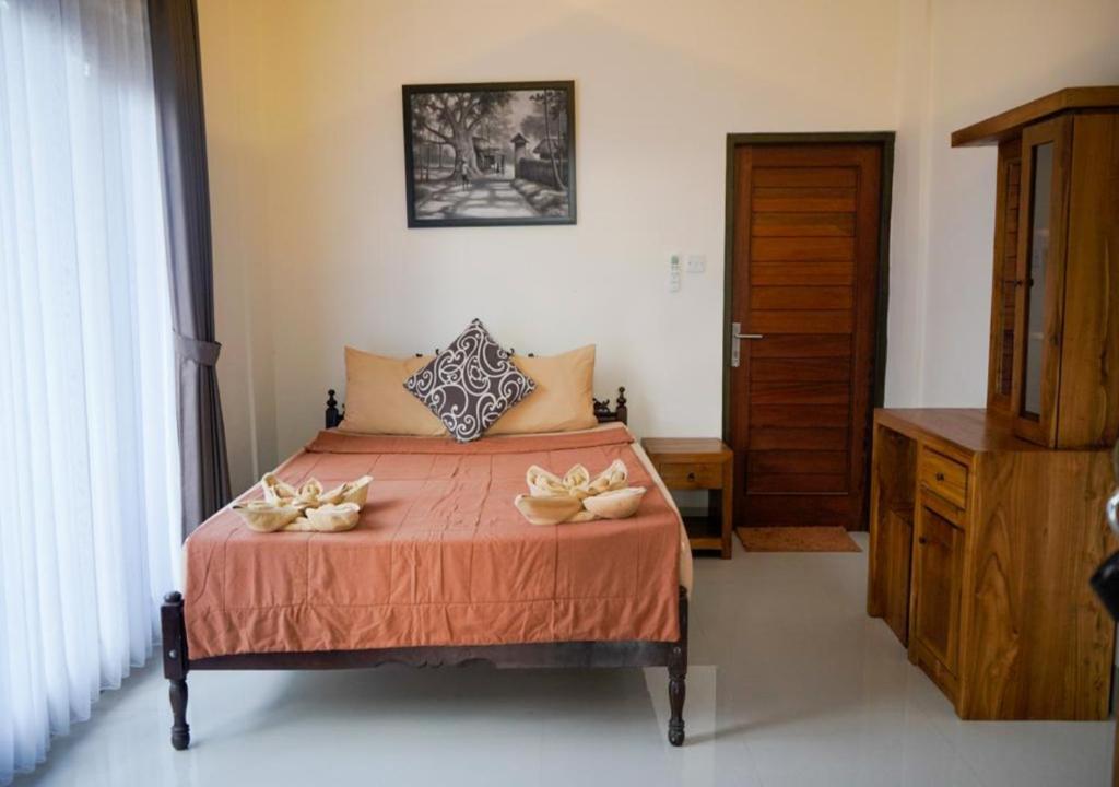 Postel nebo postele na pokoji v ubytování Adipana Bungalow-Balinese Room