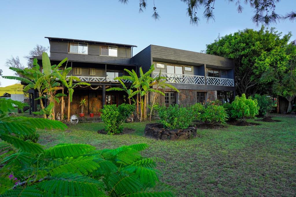 une grande maison avec un jardin en face de celle-ci dans l'établissement Hotel Uka Mana, à Hanga Roa