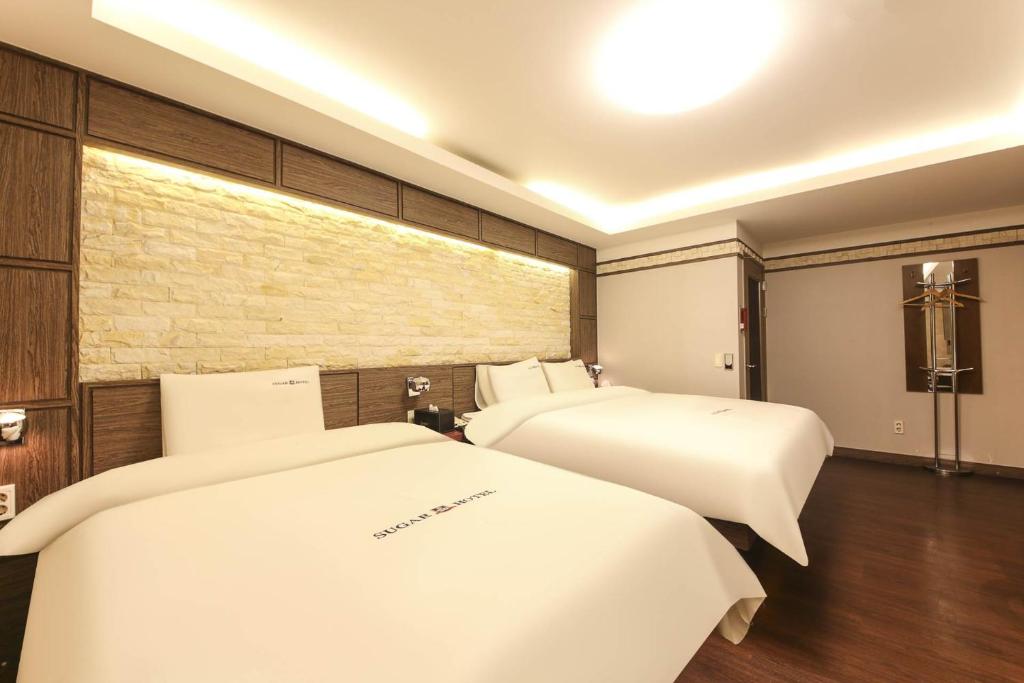 Postel nebo postele na pokoji v ubytování Sugar Hotel