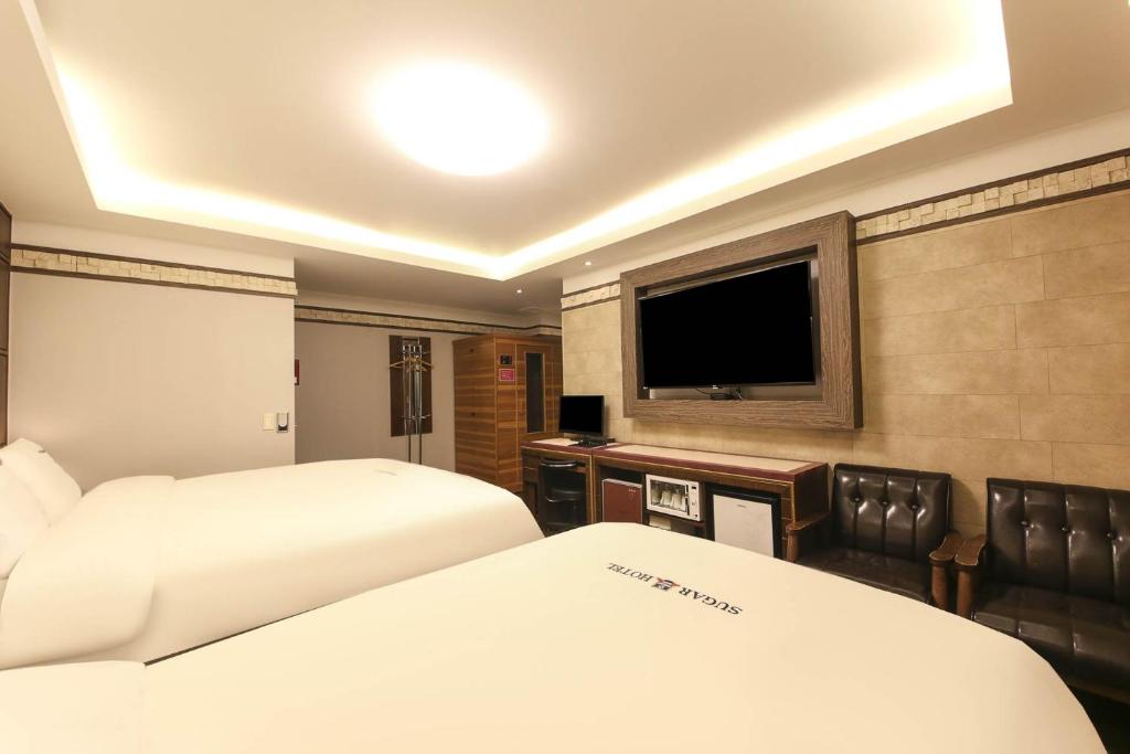 Postel nebo postele na pokoji v ubytování Sugar Hotel