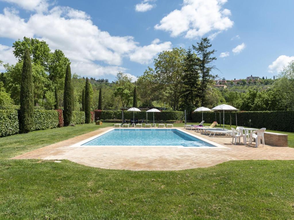 ルチニャーノにあるTuscan style apartment in Lucignano with shared poolの庭園内のプール(椅子、パラソル付)
