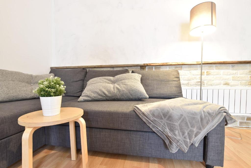 a living room with a gray couch and a table at Big place in city center with parking in Innsbruck