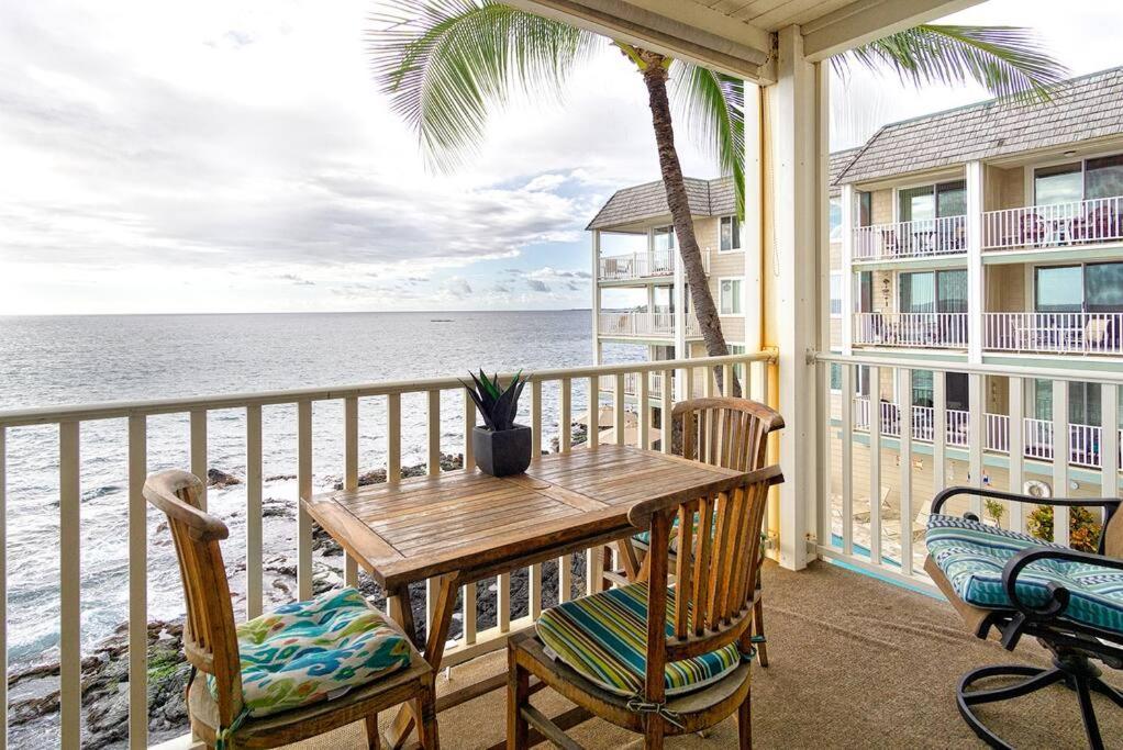 カイルア・コナにあるOceanfront Condo to Enjoy Sea Breeze and Sunset on Lanai which hangs over the ocean!! - Hale Kona Kai 305の海の景色を望むポーチ(木製のテーブル、椅子付)