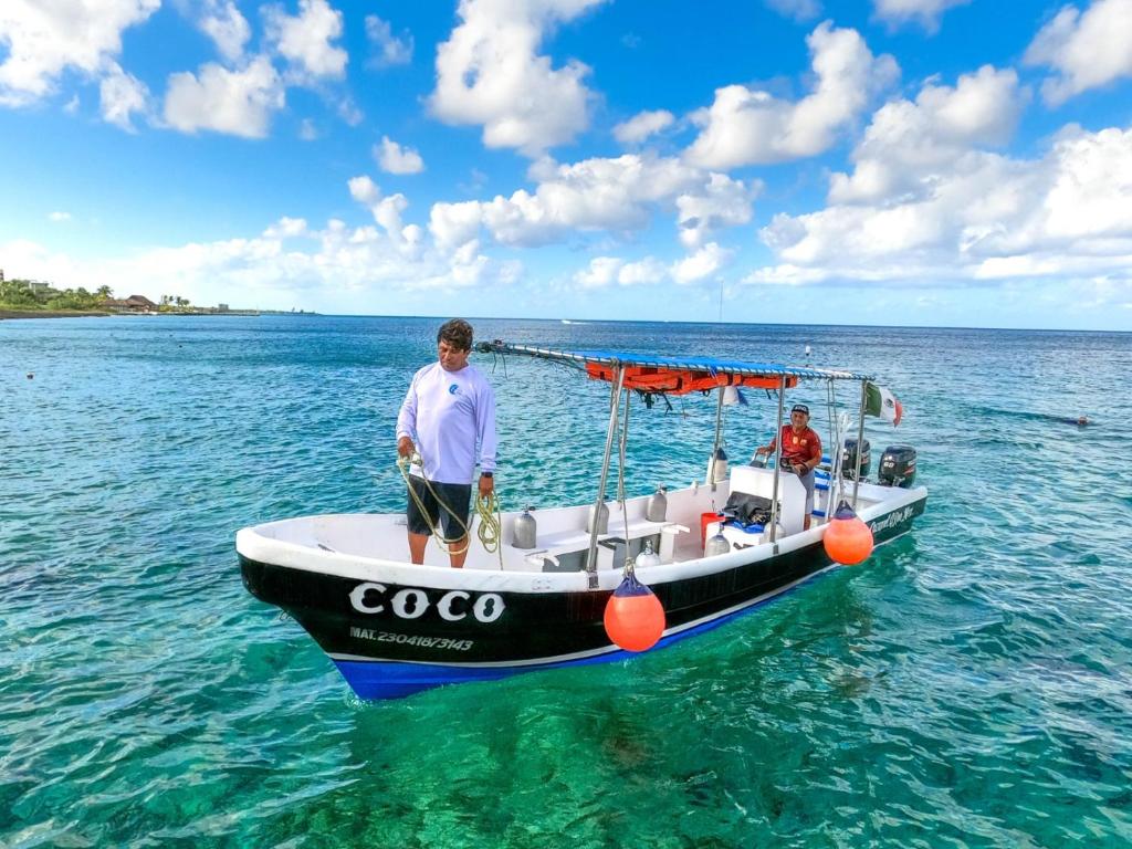 two men standing on a boat in the water at casa en playa santa clara yucatan in Santa Clara