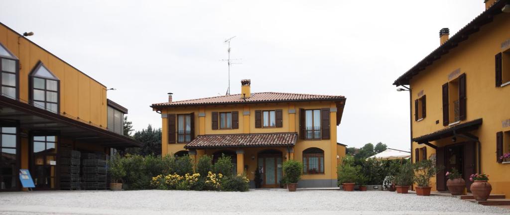 a yellow house with a roof on a street at Agriturismo Gaggioli Borgo Delle Vigne in Zola Predosa