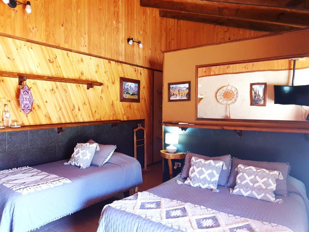 Duas camas num quarto com paredes de madeira em Alto Ciprés em Salamanca