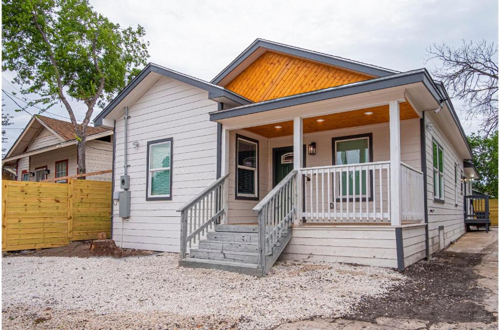 une maison blanche avec une véranda et une clôture dans l'établissement Your Dream Stay 4BR2BA Near Downtown Riverwalk, à San Antonio