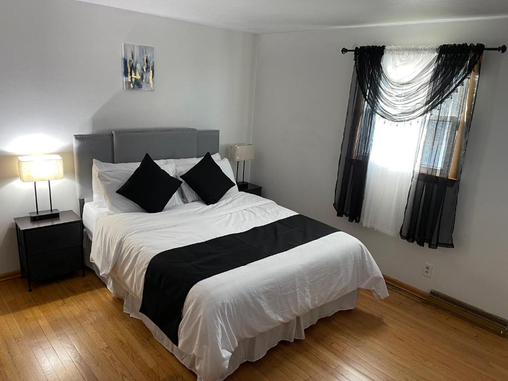 a bedroom with a large bed with black and white sheets at Elite Casa Collection -free wine, coffee, Wi-Fi, parking in Milwaukee