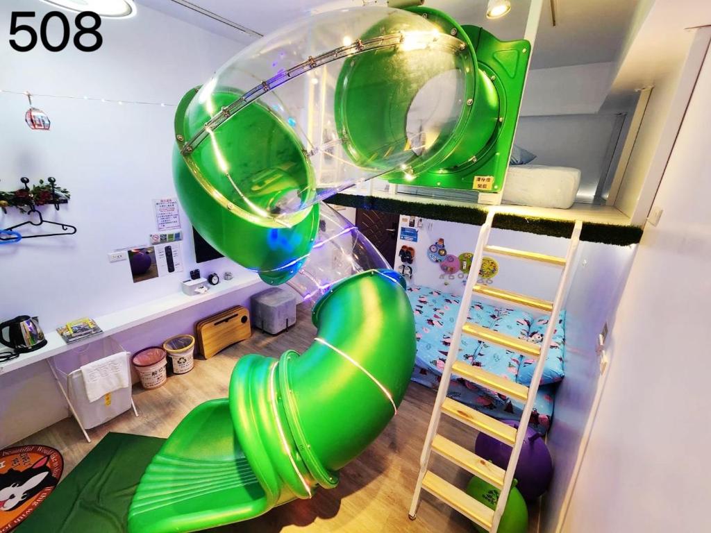 Habitación con un gran tobogán inflable verde en Wind Natural Parent-Child Inn II, en Houli