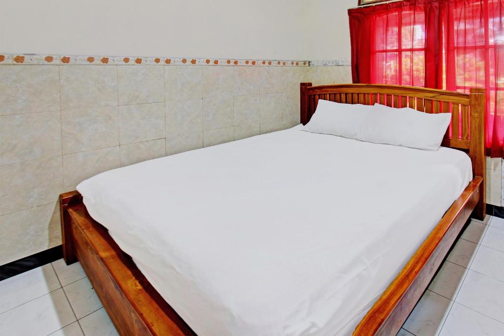 een groot bed in een kamer met rode ramen bij OYO 92560 Astri Homestay in Tjakranegara