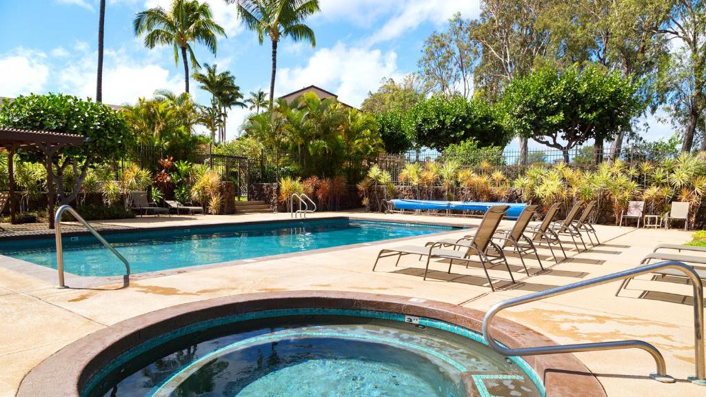 - une piscine avec des chaises et une table dans l'établissement Villa To Mar Steps To Pool Custom Made Bedrooms, à Waikoloa