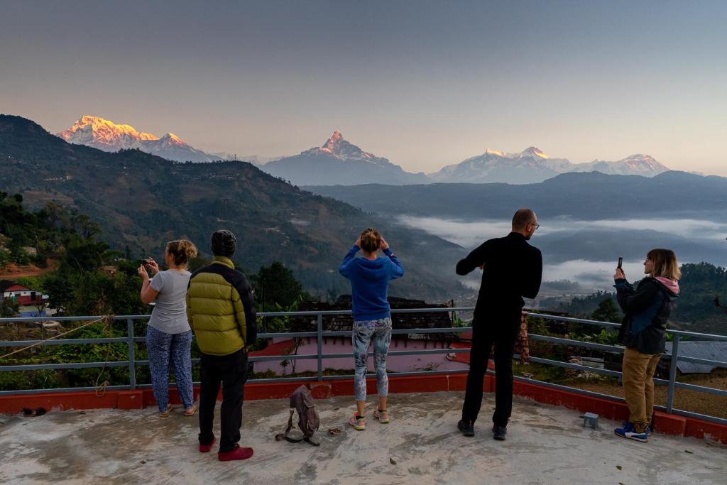 a group of people taking pictures of the mountains at Village Homestay with Culture and Nature in Pokhara